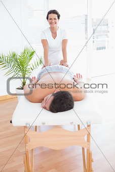 Patient relaxing on the massage table with physiotherapist behind
