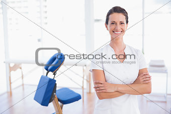 Smiling therapist standing with arms crossed