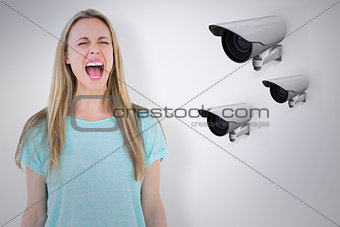 Composite image of furious blonde standing and screaming