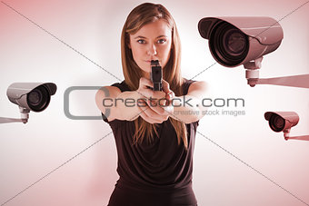 Composite image of femme fatale pointing gun at camera