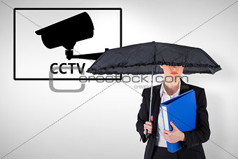 Composite image of businesswoman holding a black umbrella