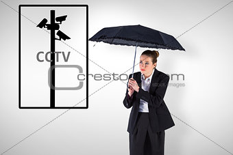 Composite image of businesswoman holding a black umbrella