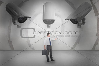 Composite image of businessman checking the time while holding briefcase