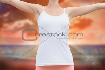 Composite image of beautiful woman with arms raised against the sky
