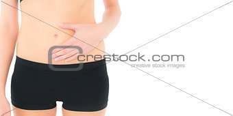 Closeup mid section of a fit woman with stomach pain