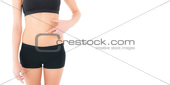 Closeup mid section of a fit woman with hand on stomach