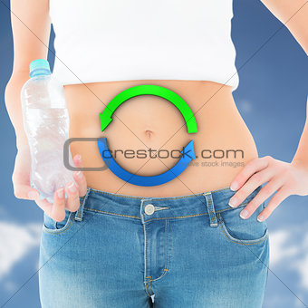 Composite image of mid section of a fit woman holding a bottle of water