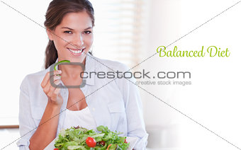 Balanced diet against smiling woman eating a salad