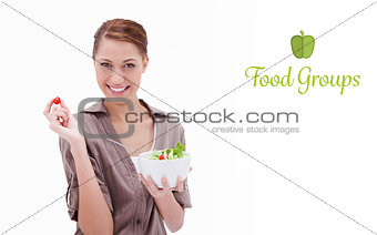 Food groups against woman with bowl of salad and small tomato in her fingers