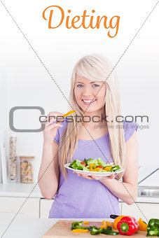 Dieting against attractive smiling female eating her salad
