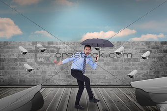 Composite image of anxious businessman under umbrella balancing