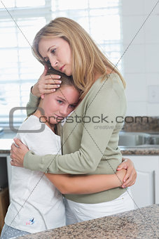 Sad little girl hugging her mother