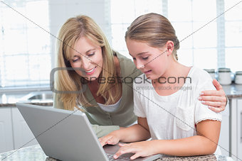 Mother and daughter using laptop together