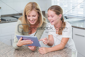 Happy mother and daughter using tablet pc together