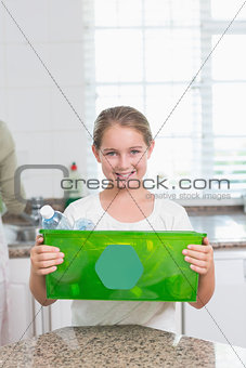 Happy little girl holding recycling box