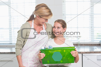 Daughter holding recycling box with her mother