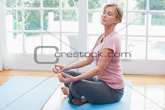 Mature woman doing yoga on fitness mat