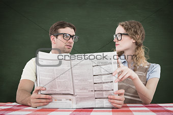 Composite image of geeky hipster couple reading newspaper
