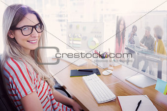 Composite image of smiling designer using tablet