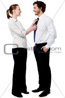 Pretty woman adjusting her husband's tie