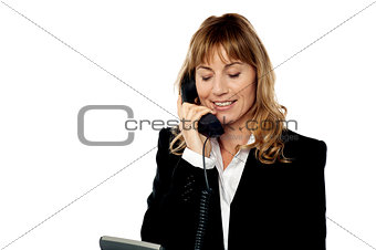 Smiling female executive attending phone call