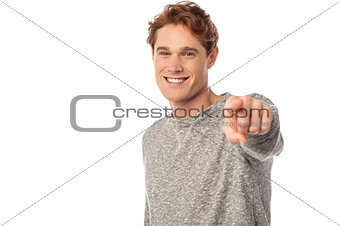 Smiling young man pointing you out