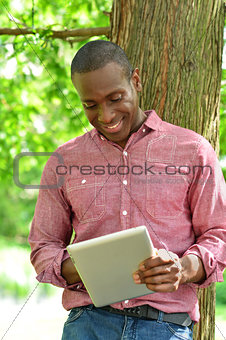 Happy middle aged man using tablet in park