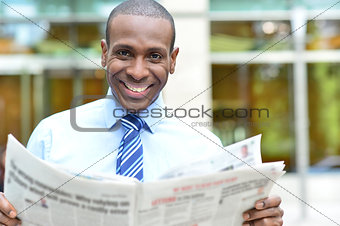 Smiling executive holding newspaper