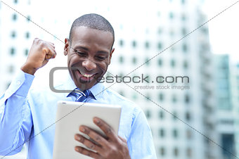 Businessman celebrates his success with tablet