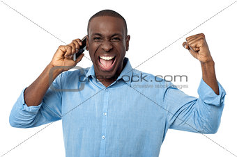 Excited african man talking on mobile phone