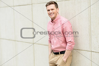 Young man posing smartly against wall