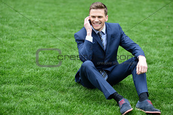 Corporate male relaxing on grass meadow