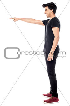 Casual young man pointing to his side