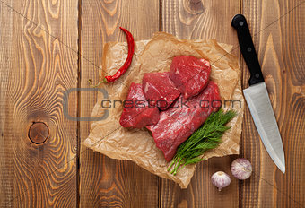 Raw fillet beef steak and spices on wooden table
