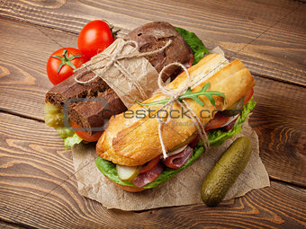 Two sandwiches with salad, ham, cheese and tomatoes