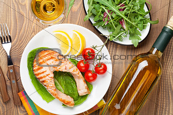 Grilled salmon and whtie wine on wooden table
