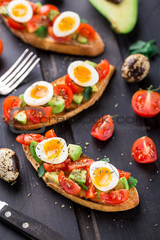 Bruschetta with tomato, avocado and quail egg