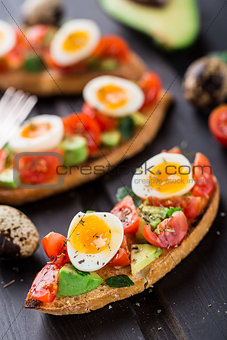 Bruschetta with tomato, avocado and quail egg
