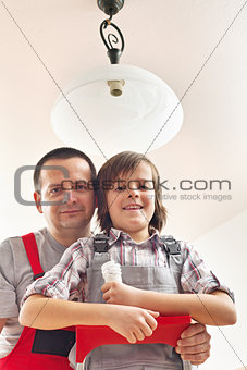 Son helping father changing a lightbulb