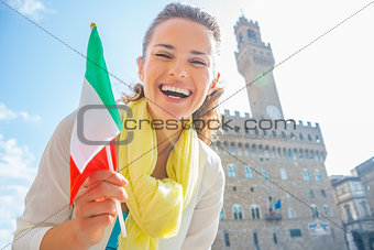 Happy young woman with flag in front of palazzo vecchio in flore