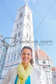 Smiling young woman in front of duomo in florence, italy