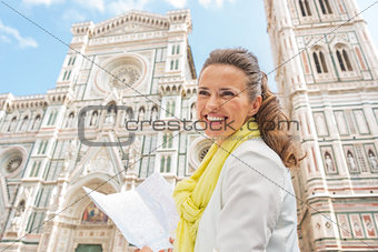 Smiling young woman with map in front of duomo in florence, ital