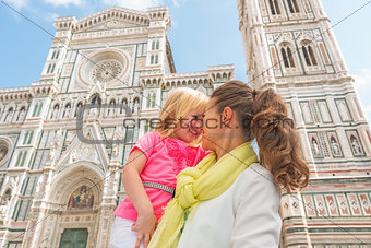 Happy mother and baby girl hugging in front of duomo in florence