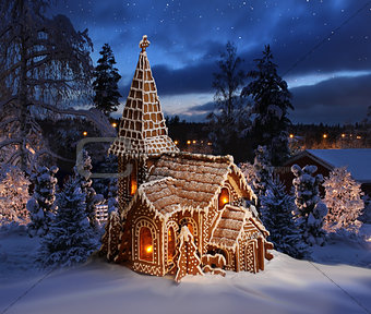 Gingerbread church on snowy Christmas night landscape