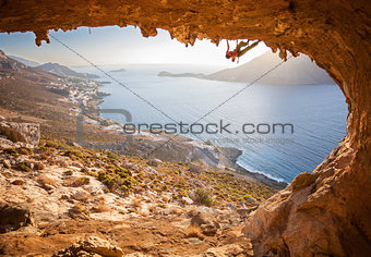 Male rock climber climbing along a roof in a cave. Kalymnos island, Greece.