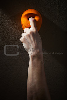 Cropped view of rock climber gripping handhold with one finger