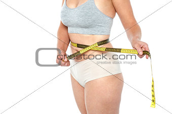 Woman in lingerie's posing with an inch tape
