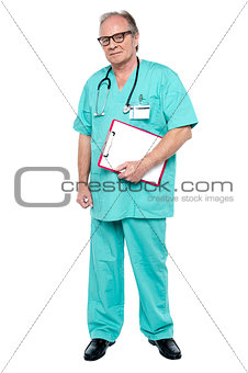 Portrait of grim faced doctor holding a clipboard