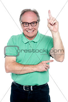 Happy old man pointing upwards