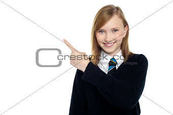 Calm and relaxed teen girl pointing sideways